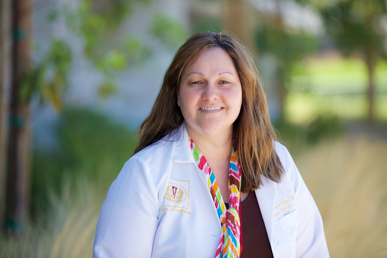 Dr. Joanna Shedd stands and smiles in her whitecoat 