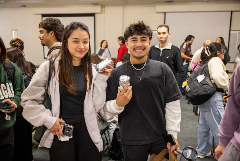 Two excited nursing students receive burritos at the end of their class.